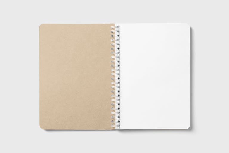 An open spiral-bound notebook with blank pages, ideal for note-taking or design mockups.