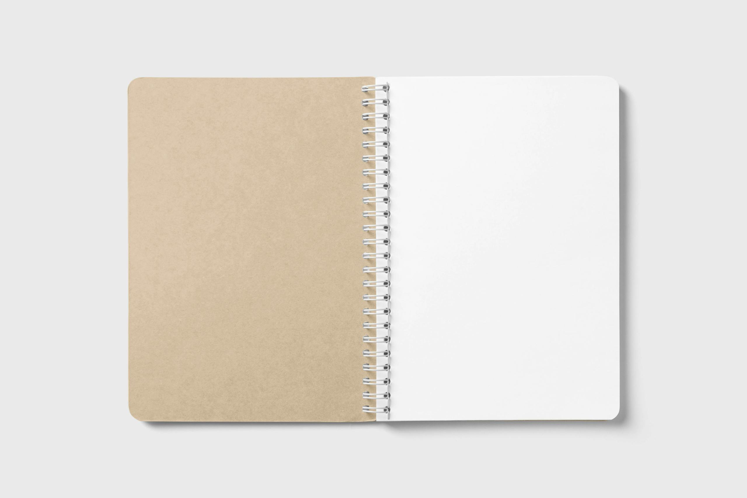 An open spiral-bound notebook with blank pages, ideal for note-taking or design mockups.